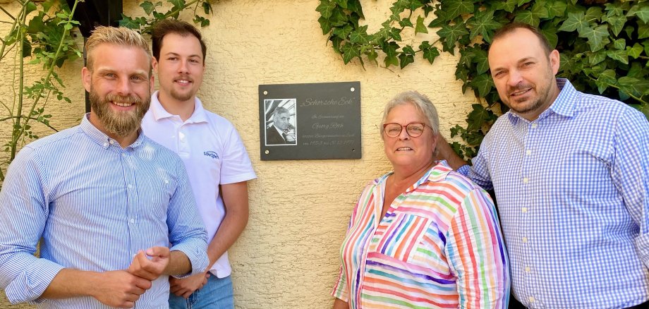 Vier Personen vor einer Gedenktafel