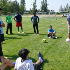 Fußballspieler sitzen und stehen im Kreis auf dem Fußballfeld