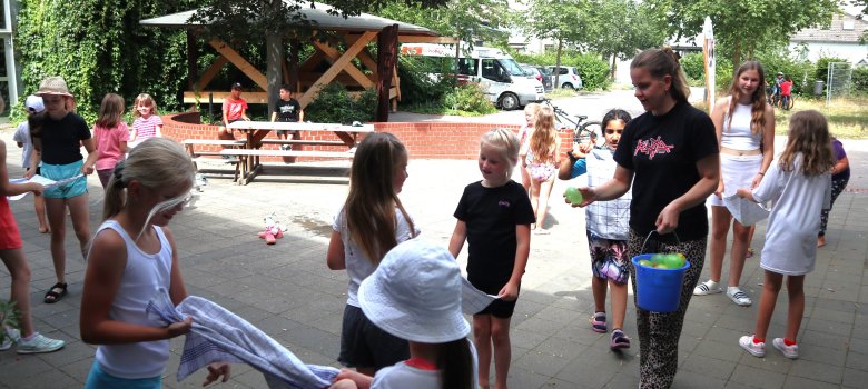 Eine junge Frau verteilt Eis an Mädchen
