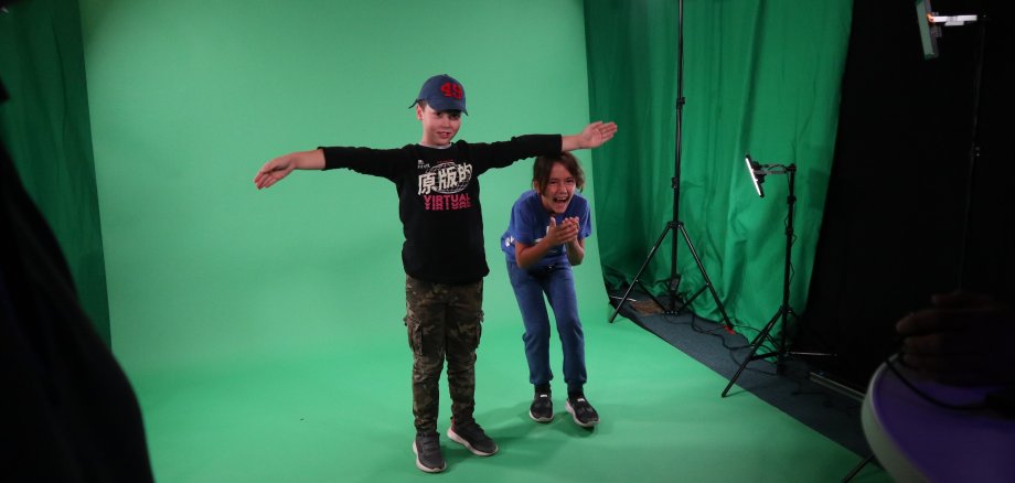 Kinder stehe vor einem Green-Screen