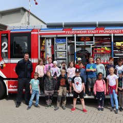 Gruppenbild mit Kindern und Feuerwehr vor einem Feuerwehrauto 