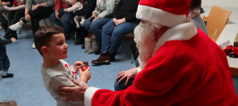 Der Nikolaus gibt einem Jungen ein Geschenk