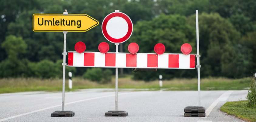 Abgesperrte Straße mit Bake und Umleitungsschild